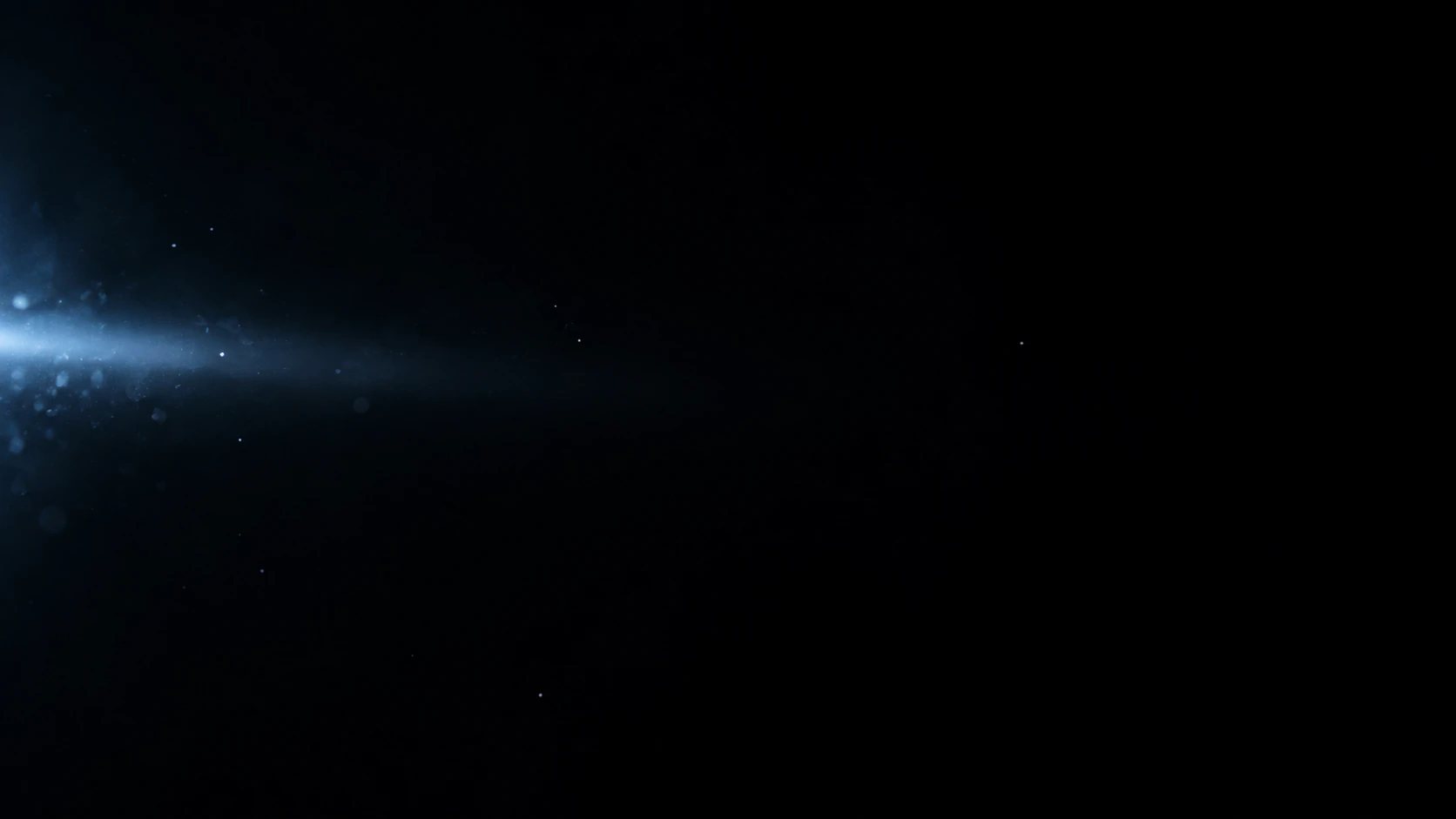 A subtle cold blue beam enters horizontally from the left edge and dissipates quickly into black, a few pinprick silver particles.