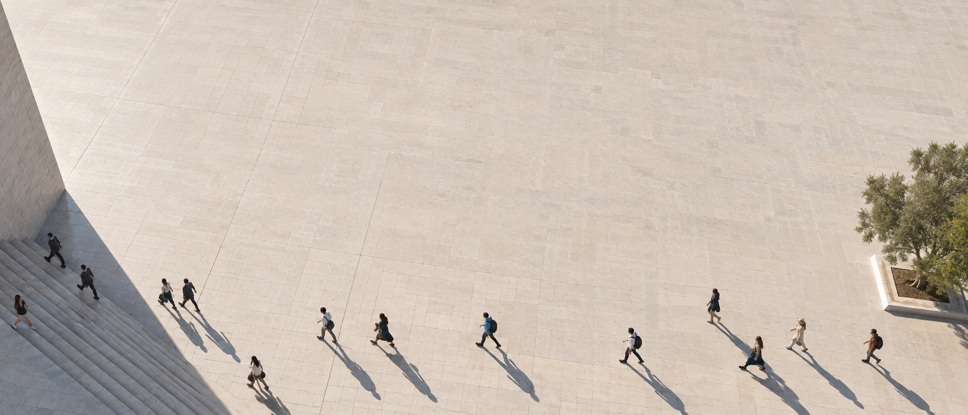 Extreme wide panoramic aerial view of a sparse stream of pedestrians moving across the bottom of an immense pale paved square, crisp afternoon shadows.
