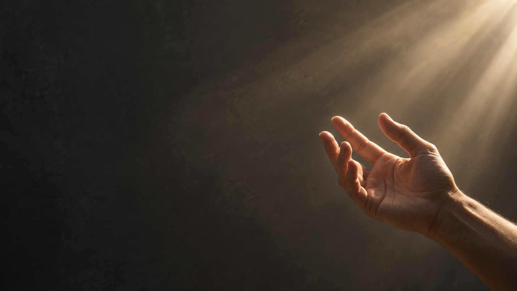 A single adult hand reaches gently into a shaft of warm daylight from the bottom right, relaxed natural fingers, calm charcoal backdrop.