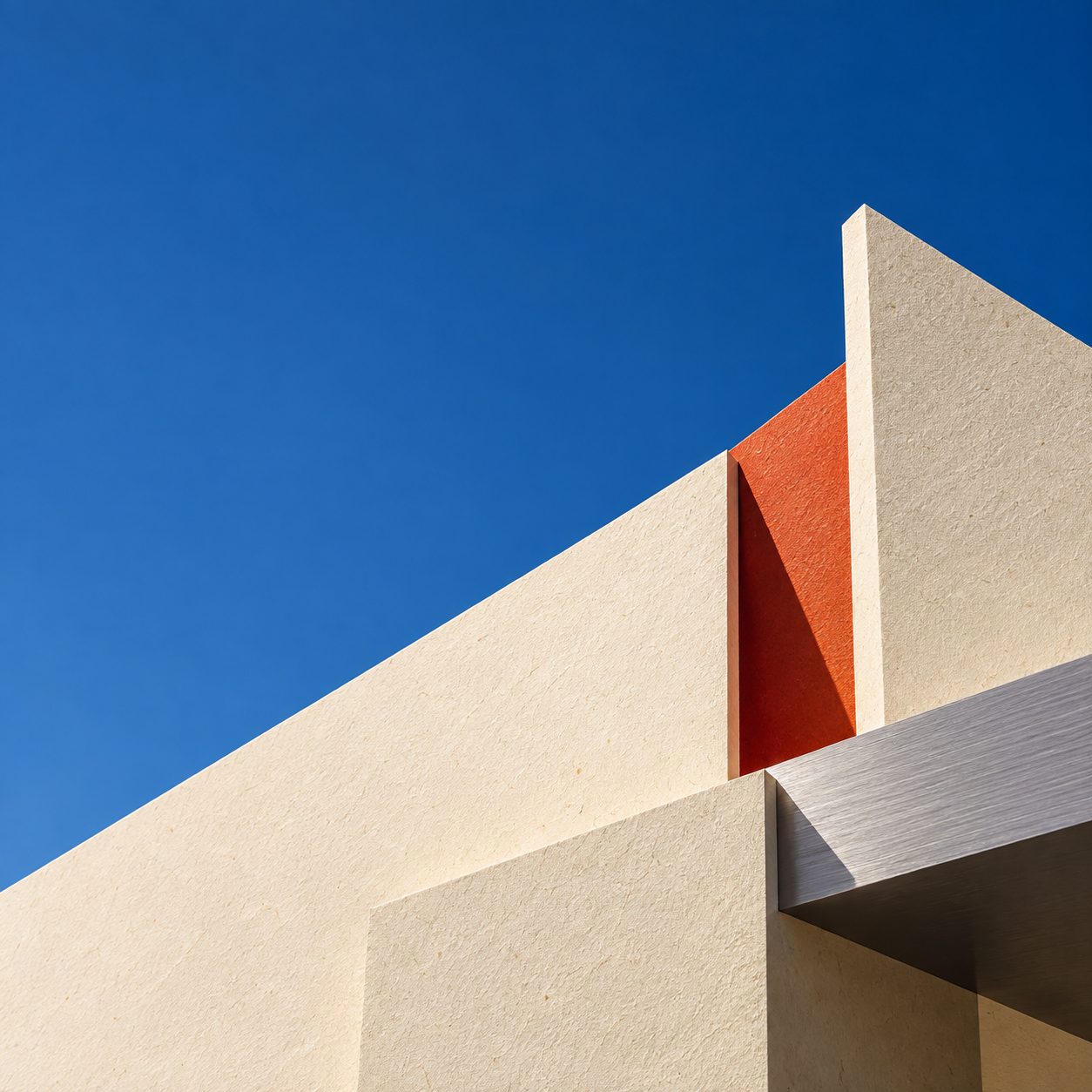 Overlapping cream architectural planes form a sculptural building under a clear blue sky.