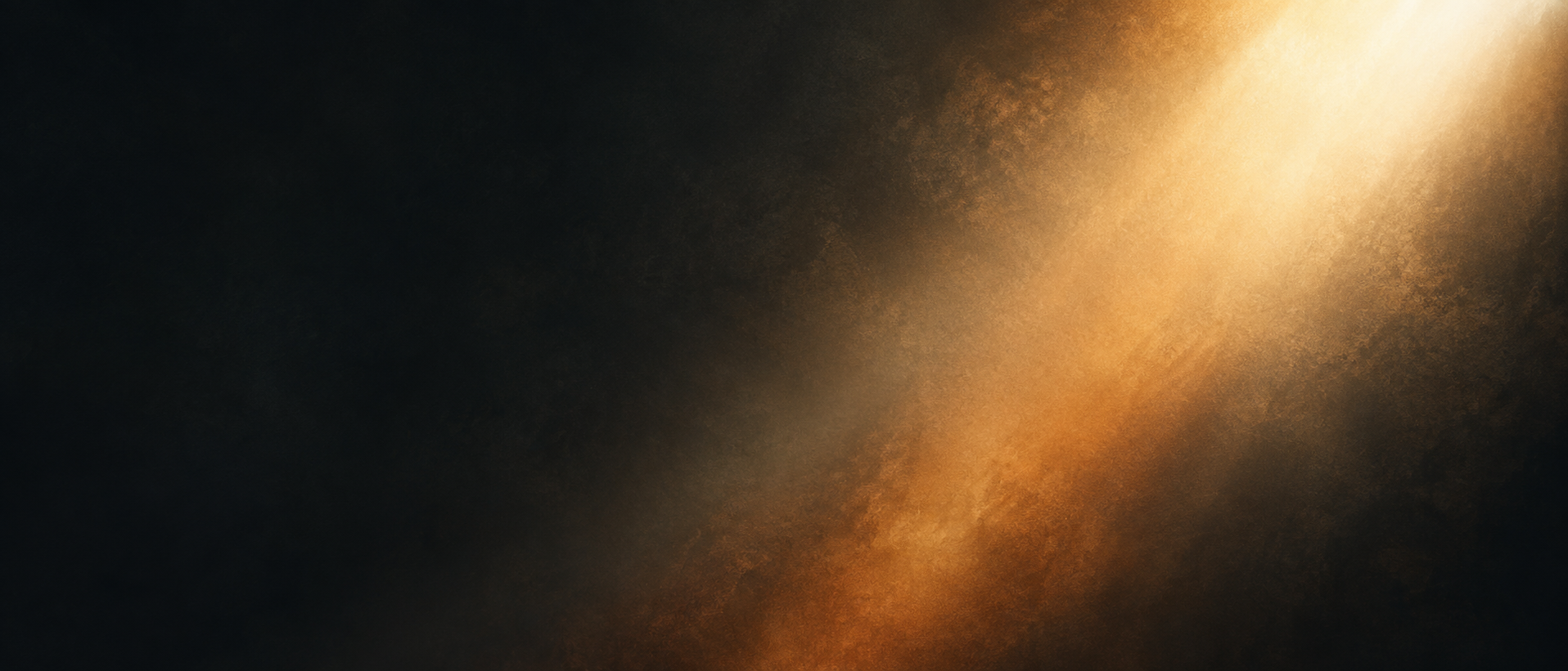 Fine amber noise in a diagonal beam across a wide black field.