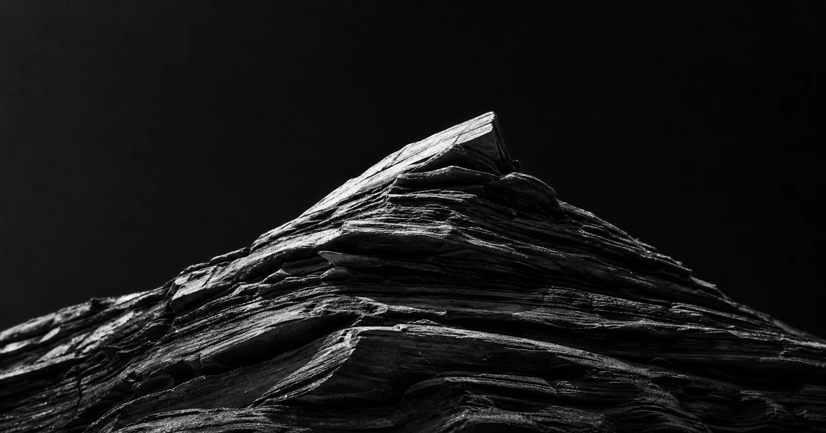A close view of a layered sculptural stone peak in cool evening shadows.