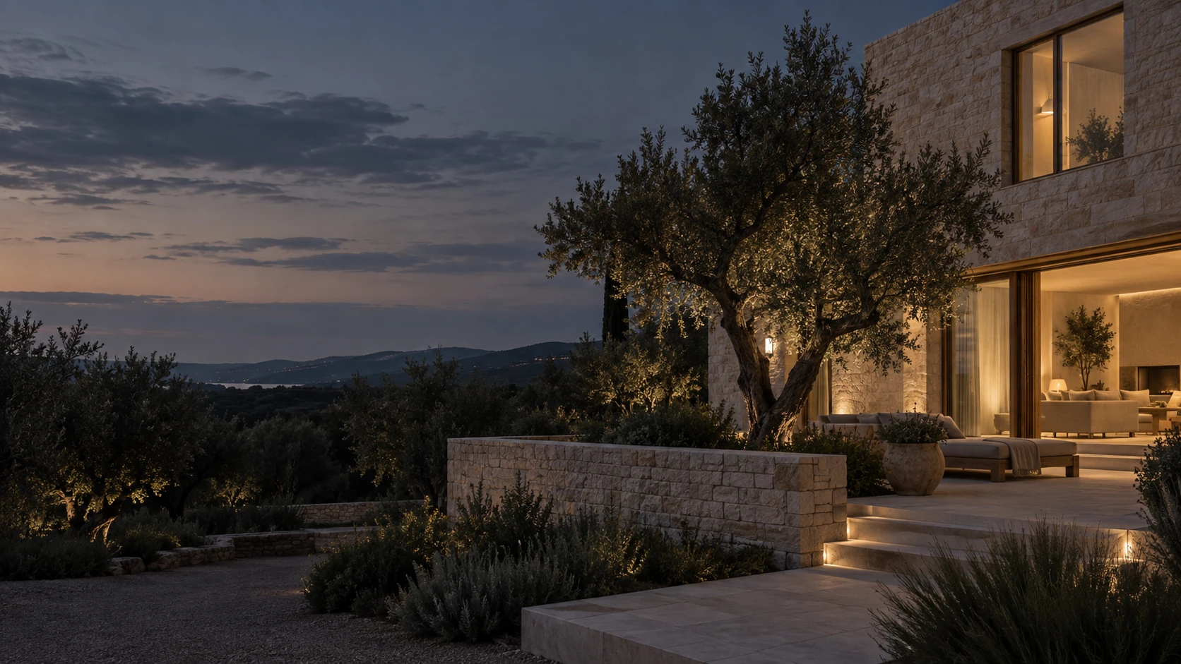 Contemporary limestone house at blue hour with warm interior windows, dark olive garden and soft slate sky, building on right and quiet dark left.