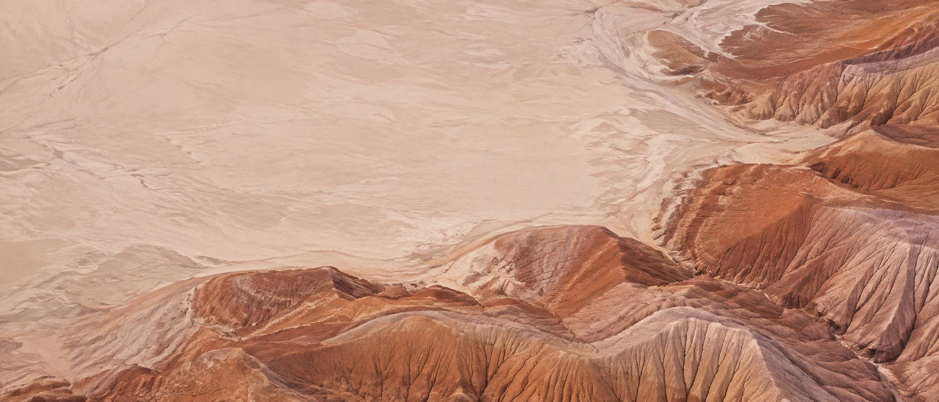 Sculpted desert lines and warm terracotta earth. Main background.